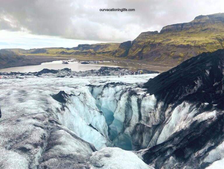 Icelandic landscape with glacier in foreground and rolling green hills in background