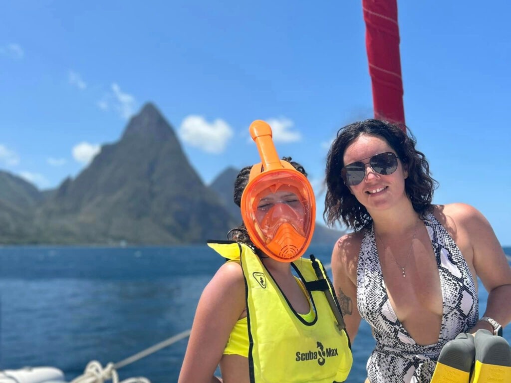 a mother and daughter on a boat in front of the Pitons in St. Lucia with snorkel gear