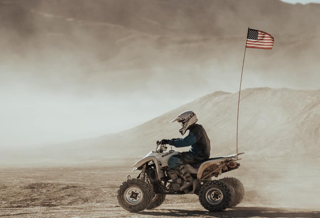 a person taking a Las Vegas ATV tour on an ATV with a USA flag flying