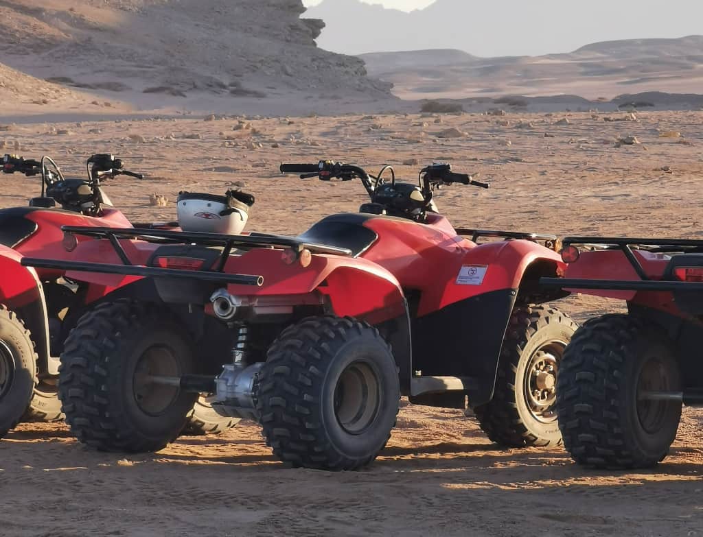 a row of red ATVs in the desert