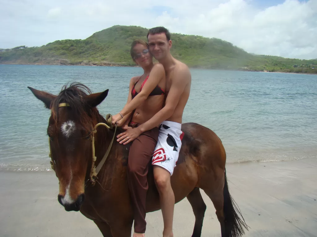 a couple on a brown horse on the beach in St. Lucia