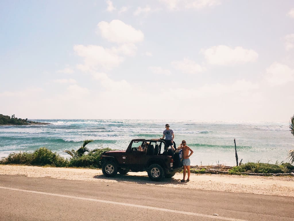a couple with a Jeep on the beach on Cozumel