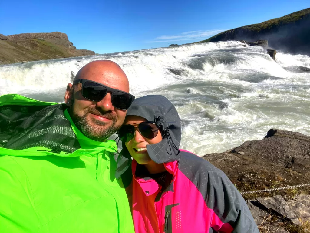 a man and woman in front of Gullfoss in Iceland
