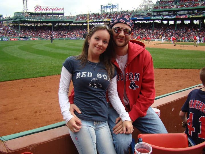 a couple at Fenway Park cheering on the Red Sox
