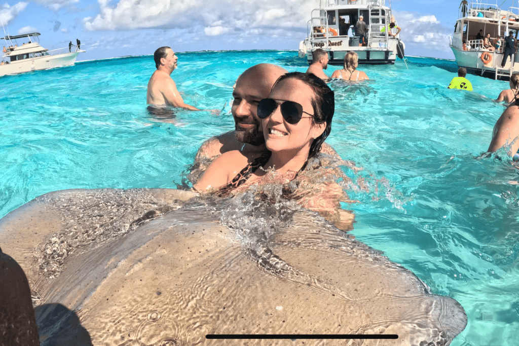 a woman and man holding a stingray