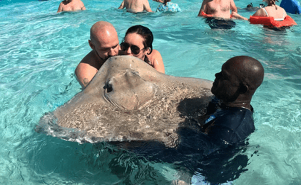a man and woman kissing a stingray