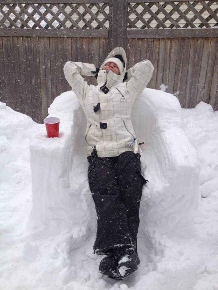 a person wearing winter packing list essentials sitting on a chair made of snow