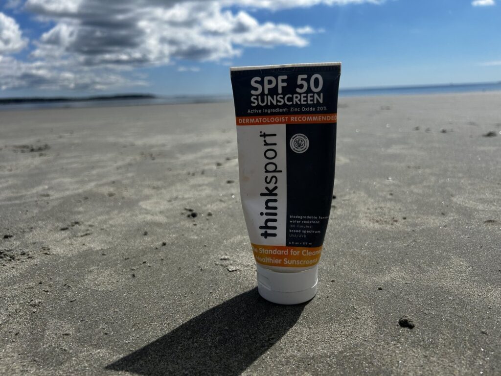 a bottle of sunscreen on the sand