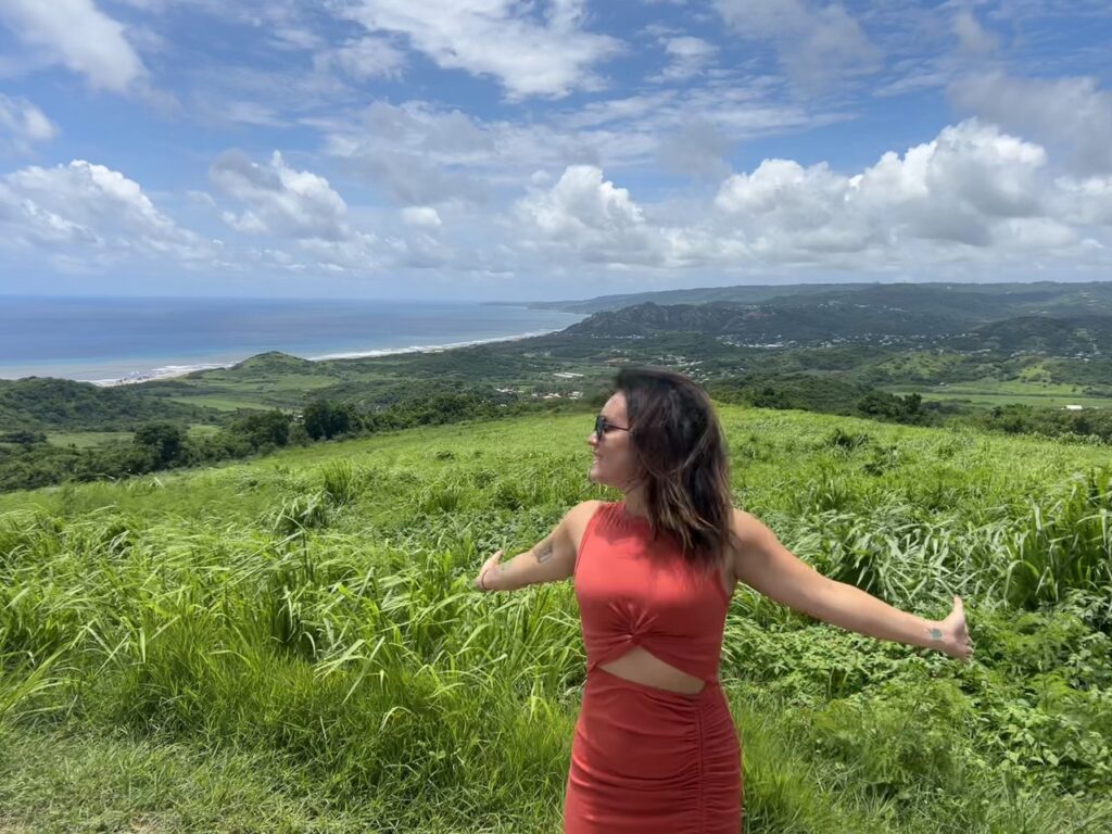 a beautiful view of the Barbados coastline, with a woman in orange in the forefront